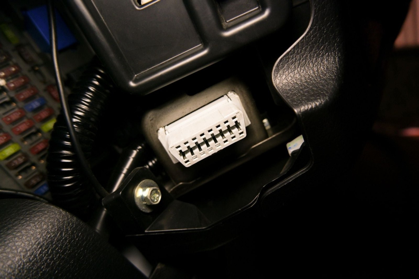 OBD2-Scanner, angeschlossen an den Diagnoseanschluss des Fahrzeugs unter dem Armaturenbrett